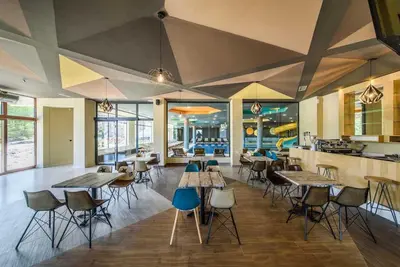 a room with tables and chairs and a kitchen at Wolf Apartments Kopaonik in Kopaonik