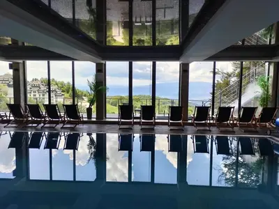 a pool with chairs in a building with windows at Mountain Bliss Residence - Milmari Spa & Wellness in Kopaonik