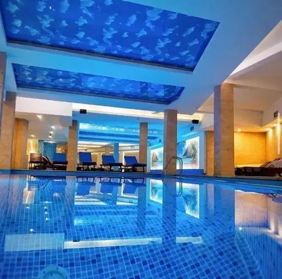 a swimming pool in a hotel with a large ceiling at Mountain Bliss Residence - Milmari Spa & Wellness in Kopaonik