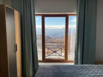 a bedroom with a large window with a view at Mountain Bliss Residence - Milmari Spa & Wellness in Kopaonik