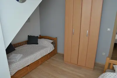 a bedroom with a bed and a wooden cabinet at Apartman Ema BIG 64m2-duplex Kopaonik in Kopaonik