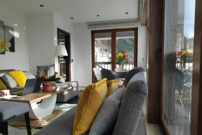 a living room with a couch with yellow pillows at Mountain View 19 Zoned II Kopaonik in Kopaonik