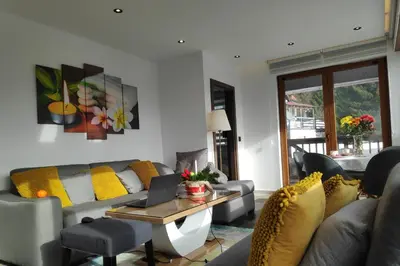 a living room with a couch and a table with a laptop at Mountain View 19 Zoned II Kopaonik in Kopaonik
