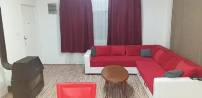 a red couch in a living room with red curtains at Apartmani Grza in Paraćin