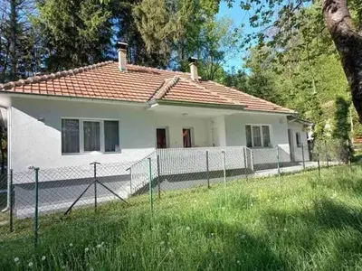 a white house with a fence in front of it at Apartmani Grza in Paraćin