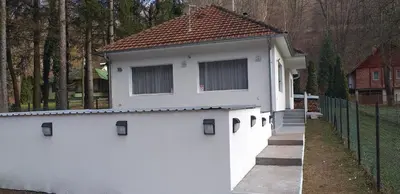 a white building with a gate and a fence at Apartmani Grza in Paraćin