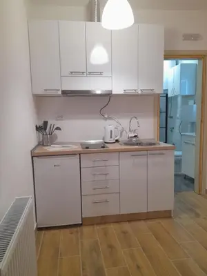 a kitchen with white cabinets and a sink at V & V Studio Apartments in Niš