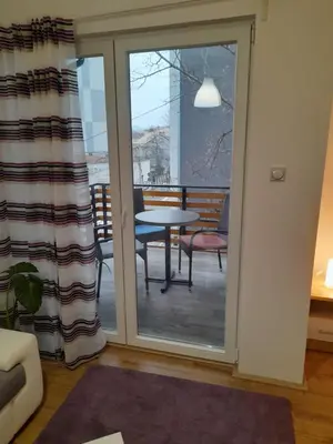 a sliding glass door leading to a patio with a table at V & V Studio Apartments in Niš