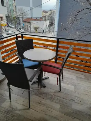 a table and chairs on a balcony with a view at V & V Studio Apartments in Niš