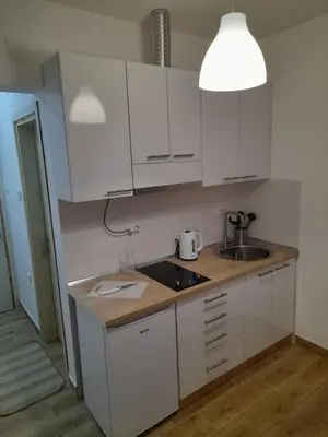 a kitchen with white cabinets and a sink at V & V Studio Apartments in Niš
