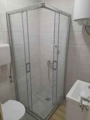 a bathroom with a shower with a toilet and a sink at V & V Studio Apartments in Niš