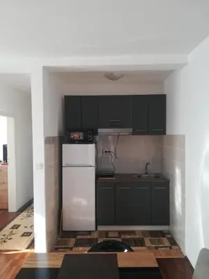 a kitchen with black cabinets and a white refrigerator at Apartman 2M Lux in Vrnjačka Banja