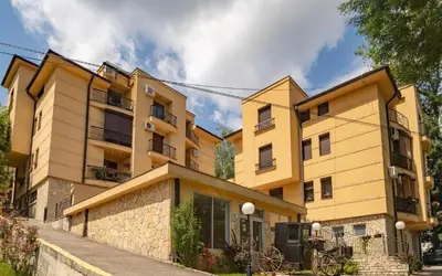 a large yellow building with at Apartman 2M Lux in Vrnjačka Banja
