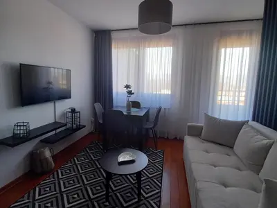 a living room with a white couch and a table at Studio Diamondlux Vrnjačka Banja in Vrnjačka Banja