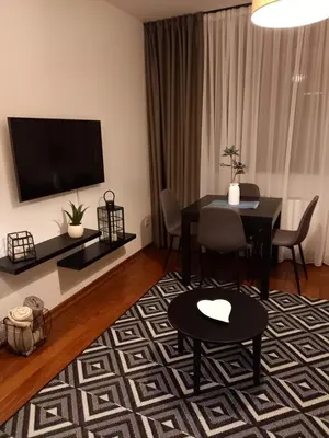 a living room with a table and a television at Studio Diamondlux Vrnjačka Banja in Vrnjačka Banja