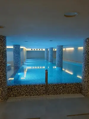 a large swimming pool with blue water in a building at Studio Diamondlux Vrnjačka Banja in Vrnjačka Banja