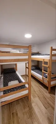 two bunk beds in a room with wooden floors at Iznad oblaka B02 in Kopaonik