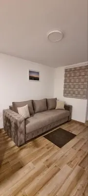 a couch in a living room with a wooden floor at Iznad oblaka B02 in Kopaonik