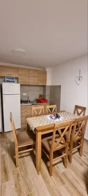 a kitchen with a table and chairs in a room at Iznad oblaka B02 in Kopaonik
