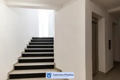 a staircase in a building with black and white steps at Sunčana Planina - Apartmani Wombat in Kopaonik