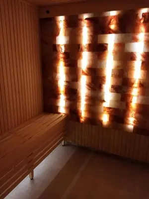 a wooden bench in a room with a wooden wall at Apolon Spa in Vrnjačka Banja