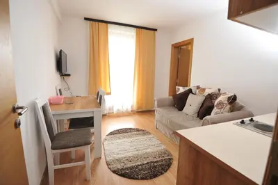 a kitchen and living room with a couch and a table at Kopaonik Apartman Sanja in Kopaonik