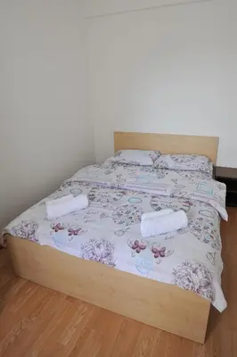 a bed with a wooden frame with two pillows on it at Kopaonik Apartman Sanja in Kopaonik