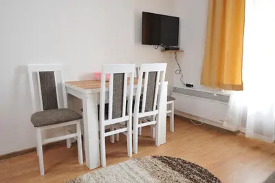 a room with a table and chairs and a tv at Kopaonik Apartman Sanja in Kopaonik