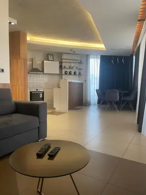 a living room with a couch and a table with remote controls at Leo lux 1 in Niš
