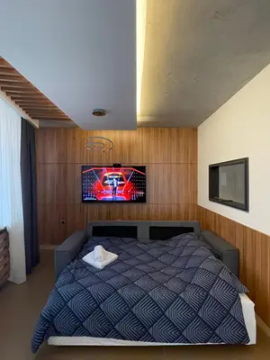 a bedroom with a bed with a tv on the wall at Leo lux 1 in Niš