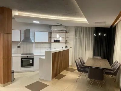a kitchen with a wooden table and chairs and a tableasteryasteryasteryasteryastery at Leo lux 1 in Niš