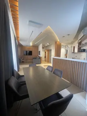 a dining room with a wooden table and chairs at Leo lux 1 in Niš