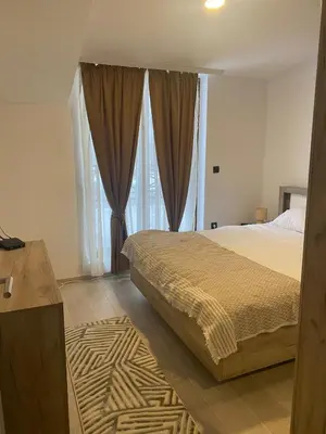 a bedroom with a bed and large windows at Milmari Apartman N92 Kopaonik in Kopaonik