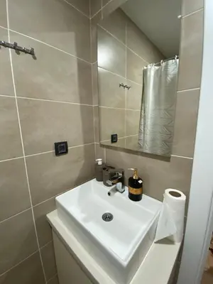 a bathroom with a white sink and a mirror at Milmari Apartman N92 Kopaonik in Kopaonik