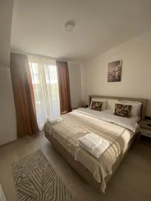 a bedroom with a large bed and a large window at Milmari Apartman N92 Kopaonik in Kopaonik