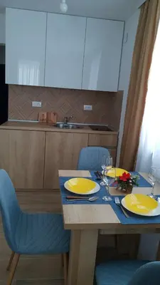 a dining room table with yellow dishes on it at Apartment Nadja in Kopaonik