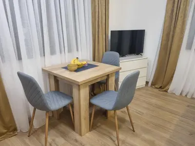 a small table with two chairs and a bowl of bananas on it at Apartment Nadja in Kopaonik