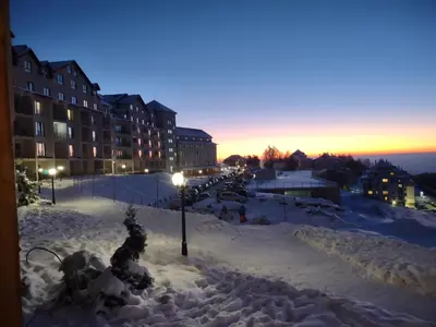 a street covered in snow in a city at night at MILMARI Kop N10 in Kopaonik