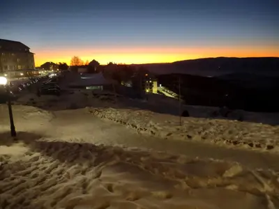a snow covered street with the sunset in the background at MILMARI Kop N10 in Kopaonik