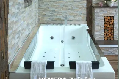 a white bath tub with two towels in a bathroom at Spa Apartman URBAN Life ZAJEČAR in Zaječar