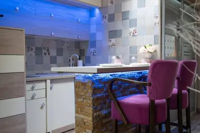 a kitchen with a purple chair at a counter at Spa Apartman URBAN Life ZAJEČAR in Zaječar