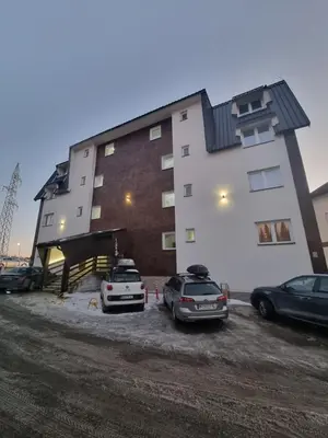 two cars parked in a parking lot in front of a building at KopStar Apartment Kopaonik G2 in Kopaonik