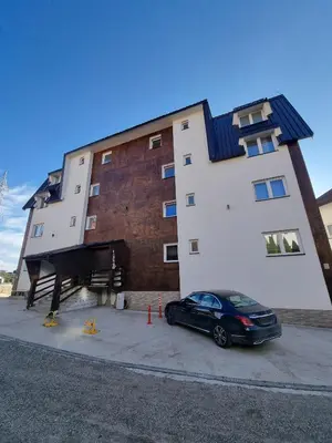 a black car parked in front of a building at KopStar Apartment Kopaonik G2 in Kopaonik