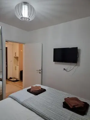 a bedroom with a bed with a flat screen tv on the wall at KopStar Apartment Kopaonik G2 in Kopaonik