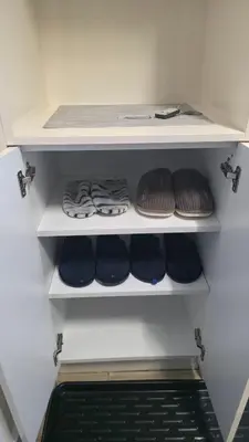 a closet with blue and brown shoes on shelves at KopStar Apartment Kopaonik G2 in Kopaonik