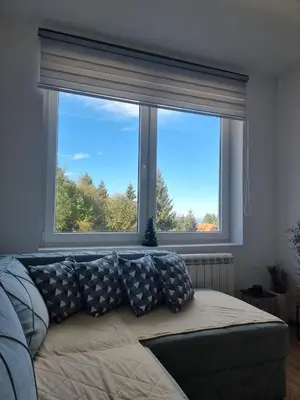 a living room with a large window and a couch at KopStar Apartment Kopaonik G2 in Kopaonik