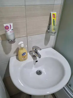 a bathroom sink with a bottle of soap and a mirror at ZVEZDA LUX in Kruševac