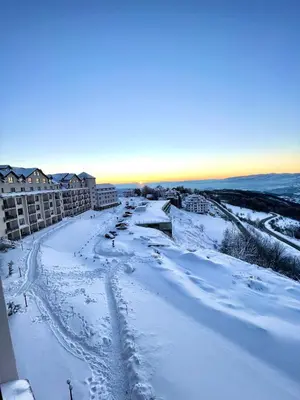 a snow covered street in a city with buildings at Milmari N69 in Kopaonik