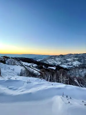 a group of people skiing down a snow covered slope at Milmari N69 in Kopaonik