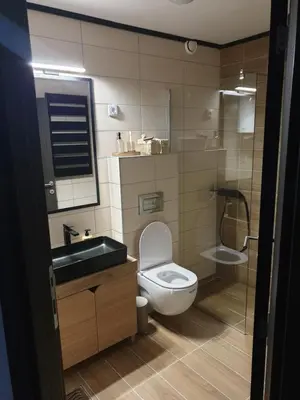 a bathroom with a toilet and a sink and a mirror at Apartman Noalux 2 Kopaonik in Kopaonik